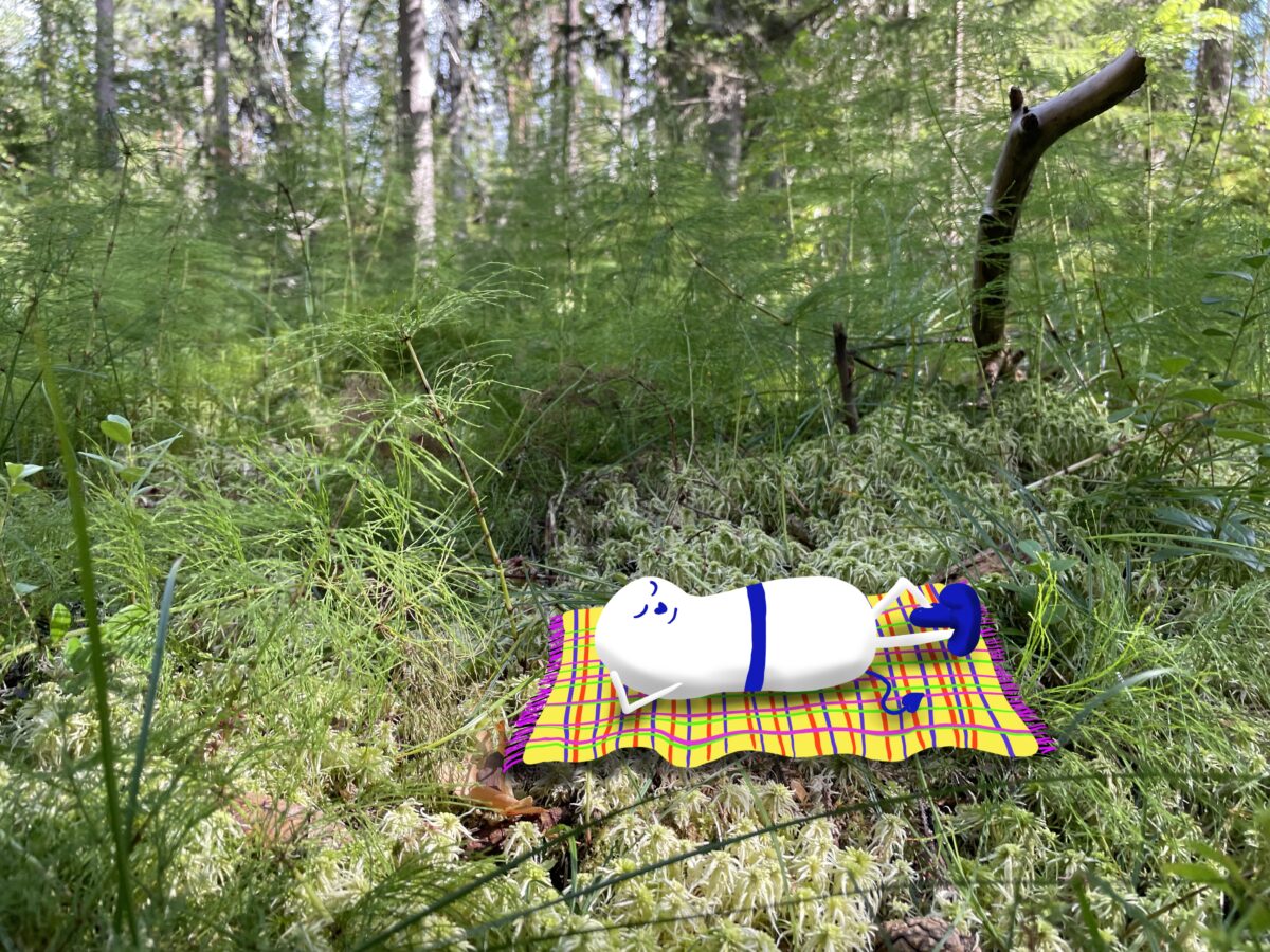 Foto eines Waldbodens, hineingezeichnet ein weisses ovales Wesen auf einer bunten Picknickdecke
