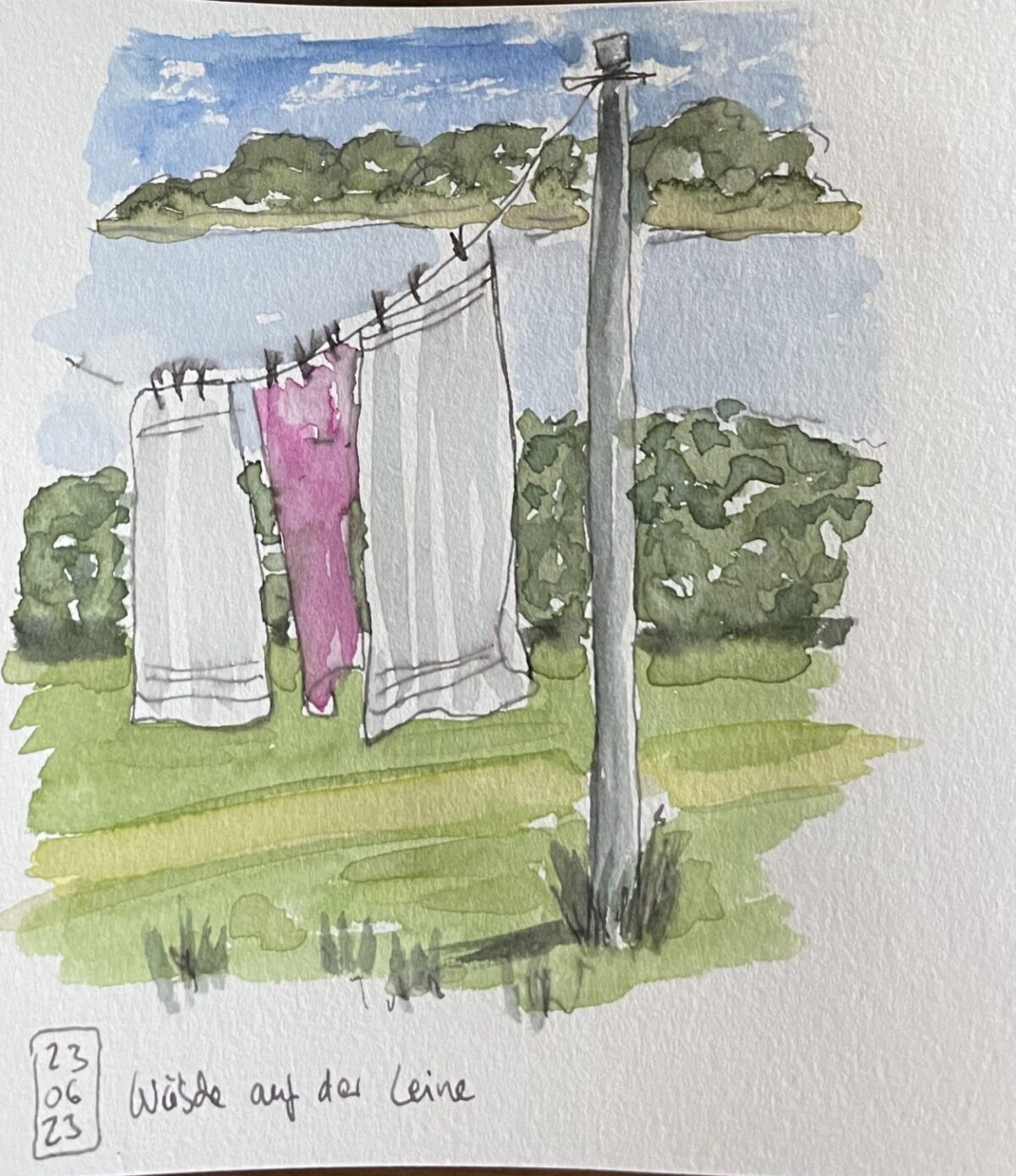 Ein Motiv im Skizzenbuch: ein kleines Aquarell von 3 Handtüchern auf einer Wäscheleine im Garten.